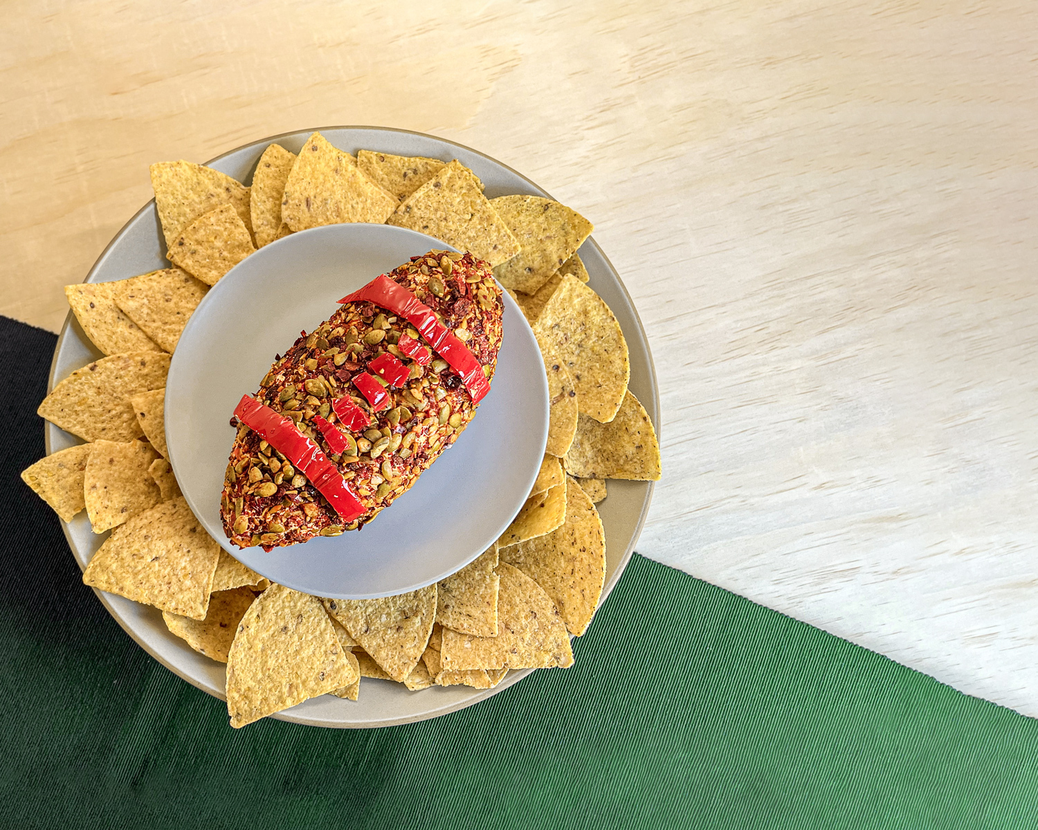 Football-shaped cheese ball on a platter with tortilla chips